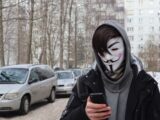 a person wearing a mask and holding a cell phone