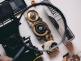 person using magnifying glass to see gold and white device gear