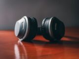 Close-up of sleek wireless headphones on a wooden surface, perfect for music enthusiasts.