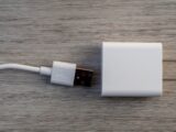 White usb charger and cable on wooden surface