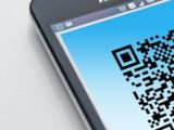 High-resolution close-up of a smartphone displaying a QR code on its screen.