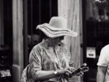 A woman wearing a vintage-style straw hat explores the streets of İstanbul. Black and white photo.