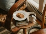 Coffee and cookies on a small table next to chair