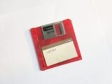 red and white floppy disk on white surface