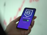 Hand holding smartphone displaying blockchain cryptocurrency wallet.