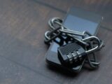 Close-up of a smartphone wrapped in a chain with a padlock, symbolizing strong security.