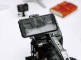 Close-up of a professional camera rig with monitor display in a studio setting, ideal for filmmaking.