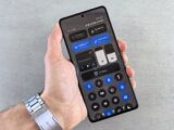 Hand holding smartphone displaying dark mode interface