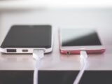 Two smartphones charging side by side on a desk. Modern and technological setting.