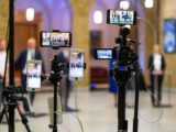 Multi-camera setup capturing a live event indoors, showcasing modern filming technology.