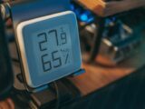 Close-up of a digital hygrometer showing temperature and humidity indoors.