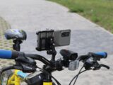 Bicycle handlebars with phone and lights attached.