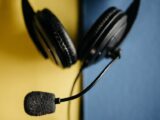 A detailed view of a black headset with microphone on a blue and yellow background, ideal for tech themes.