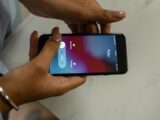 Close-up image of hands holding a smartphone receiving a call from Ruby on a marble surface.