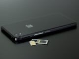 Close-up of a smartphone with a SIM card and memory card, showcasing modern technology.