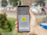 Smartphone showing active eSIM plan held outdoors, blurred city background.