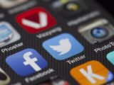 A detailed close-up of social media icons on a smartphone screen, including Facebook and Twitter.