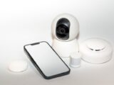 Collection of smart home security gadgets with a smartphone display.