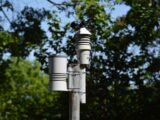 Close-up of an anemometer and weather device on a sunny day outdoors.