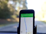 Smartphone displaying GPS navigation route on Natchez Trace Parkway inside a car.