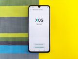 Smartphone on colorful background showing XOS version update, based on Android.