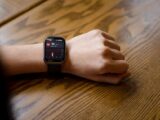 Close-up of a smartwatch displaying a heart rate of 90 bpm on a person's wrist.