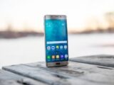 Samsung smartphone placed on a wooden surface outdoors during sunset.