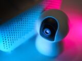 Close-up of a surveillance camera with neon lighting, symbolizing modern home security technology.
