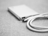 Monochromatic close-up of an external hard drive with a USB cable.