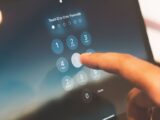 Close-up of a finger entering a passcode on a smartphone security screen.