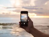 person holding smartphone showing ocean