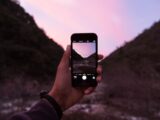 person holding iPhone displaying camera application