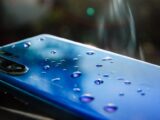 A sleek blue smartphone with water droplets showcasing modern technology and design.