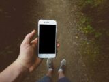 person holding silver iPhone 6 with black case