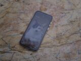 A phone with a cat wallpaper on marble.