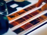 Close-up of film negatives being scanned with professional equipment in a studio setting.