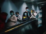 People wearing masks on an escalator in Shanghai during pandemic times.