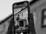 Black and white close-up of a smartphone capturing an old building facade.