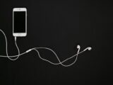 white iphone 5 c beside white earbuds