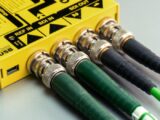 Vibrant close-up of green SDI cables connected to yellow device with visible USB port.